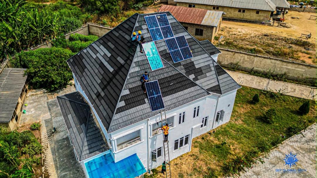 Aerial view of solar panels being installed on a white house