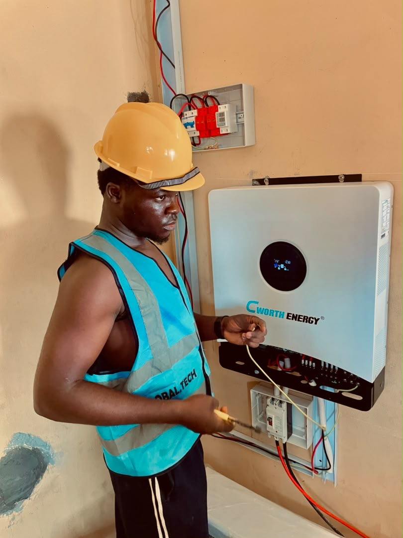 Installer connecting cables at an open inverter