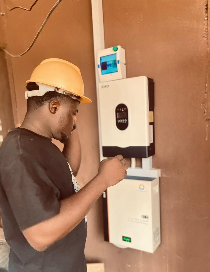 Installer checking a wall-mounted inverter